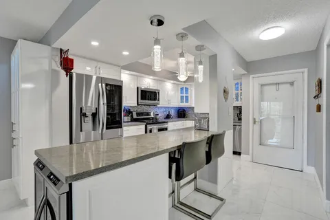 a kitchen with stainless steel appliances a sink stove and refrigerator