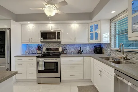 a kitchen with stainless steel appliances granite countertop a stove sink and microwave