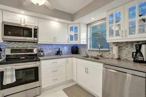 a kitchen with a sink stainless steel appliances and cabinets