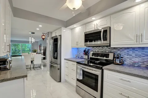 a kitchen with a sink and chairs
