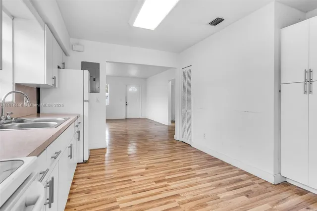 a kitchen with a sink and wooden floor