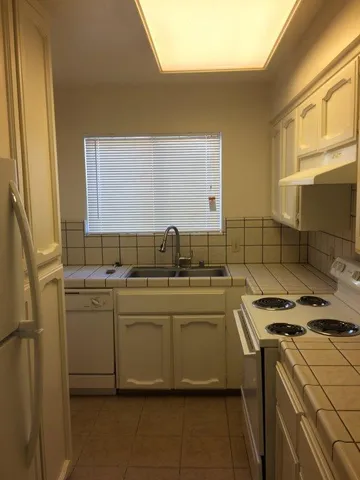 a kitchen with stainless steel appliances a sink stove and cabinets