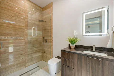a bathroom with a granite countertop sink a toilet and a shower