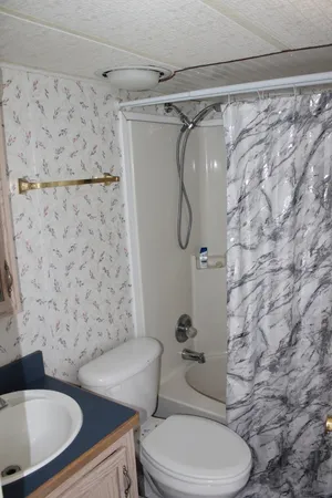 a bathroom with a toilet and a shower curtain