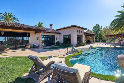 a view of a house with swimming pool and sitting area