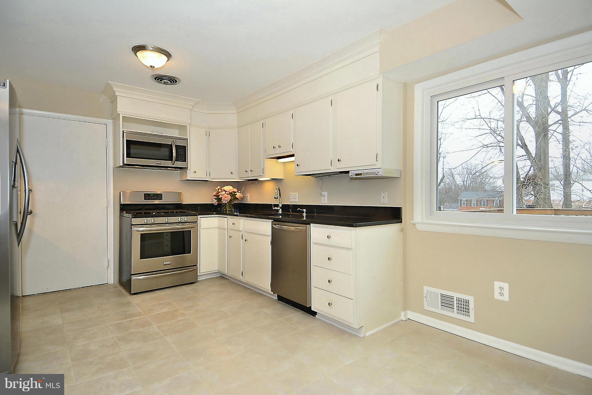 1870 Beulah Road Vienna, VA 22182 - Photo 5 of 30 a kitchen with granite countertop white cabinets and stainless steel appliances
