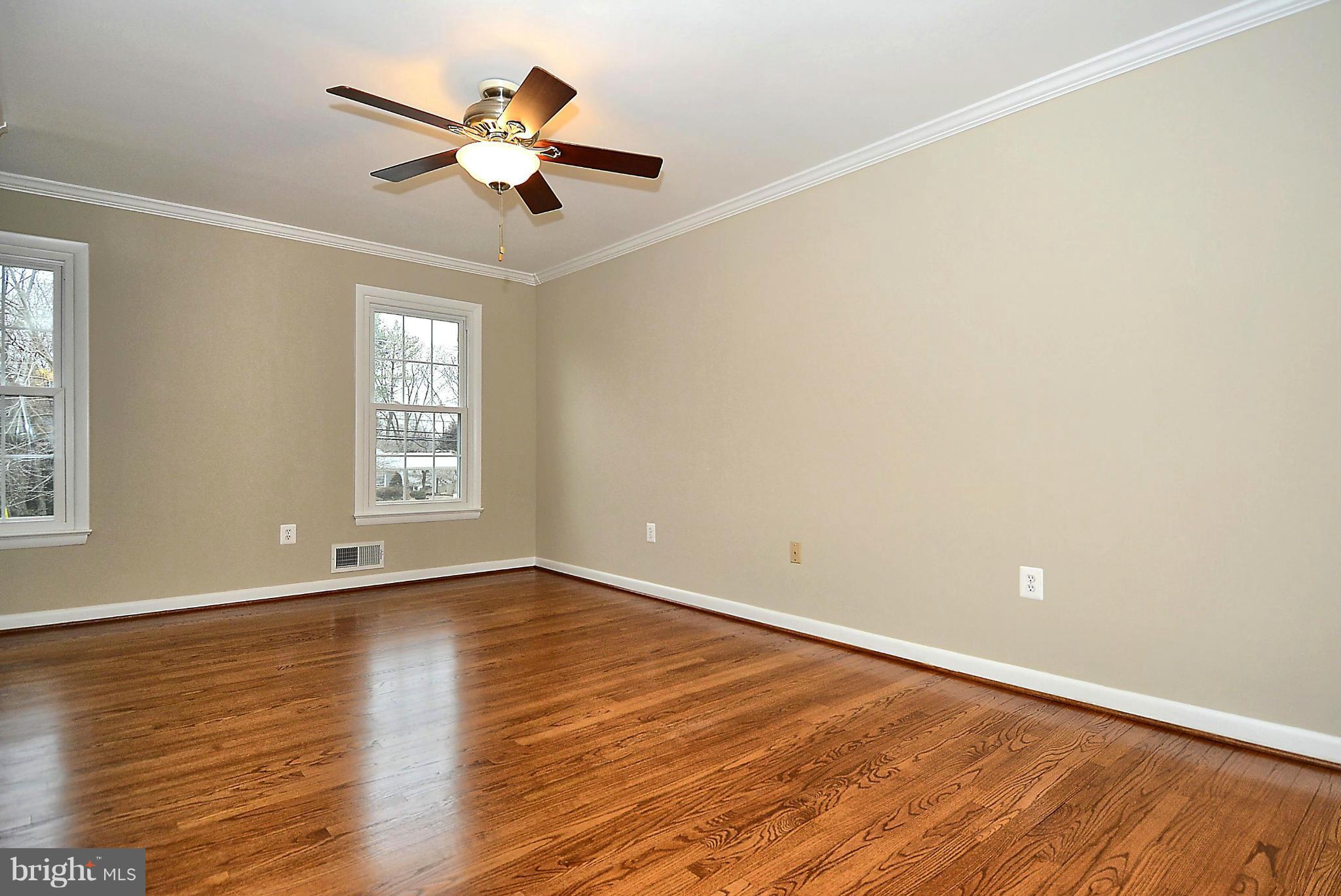 1870 Beulah Road Vienna, VA 22182 - Photo 10 of 30 an empty room with wooden floor chandelier fan and windows