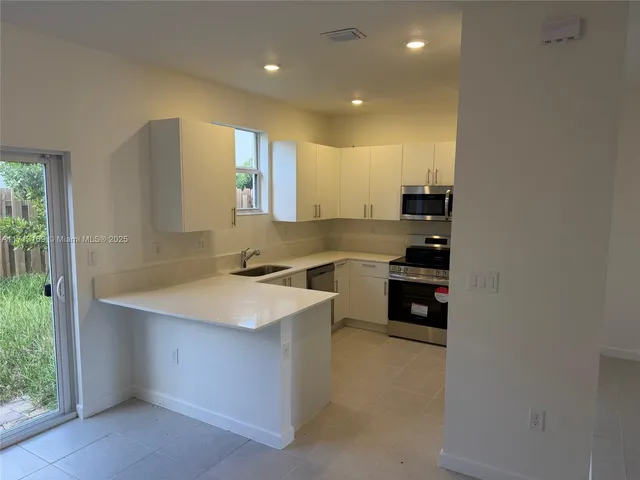 a kitchen with stainless steel appliances a sink stove and cabinets