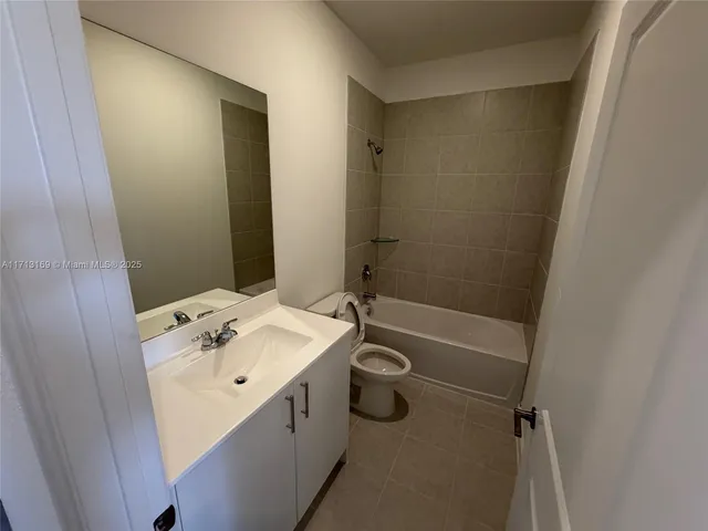 a bathroom with a sink a granite tub shower and mirror