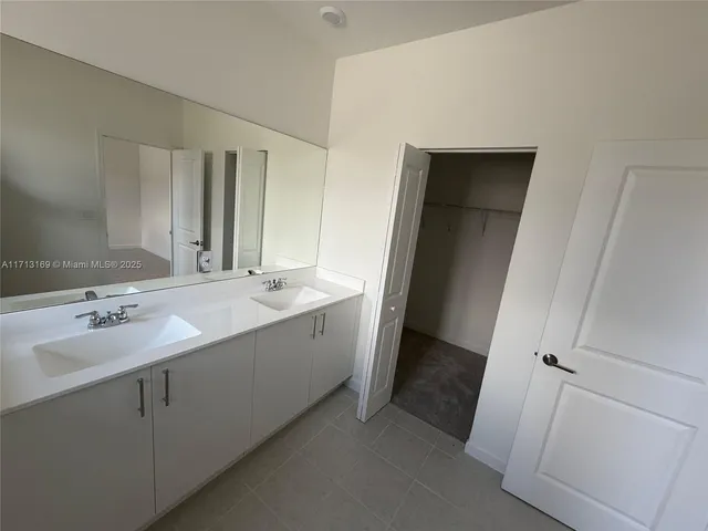 a bathroom with a double vanity sink and mirror