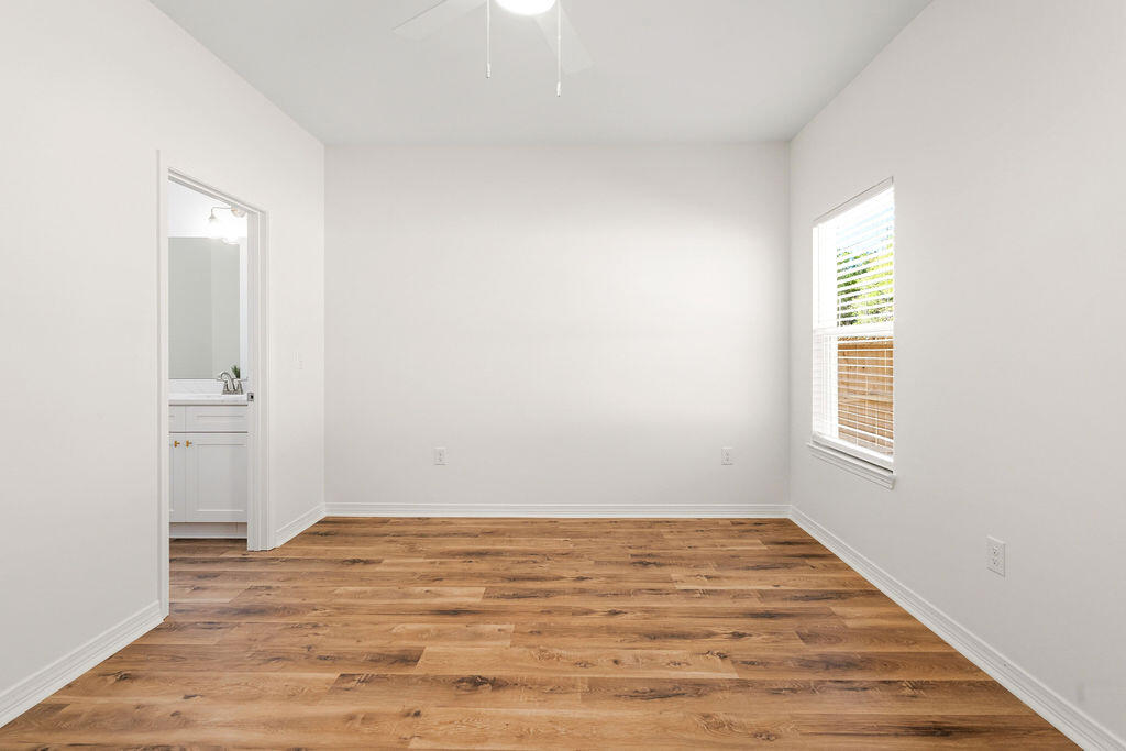 3812 Golden Acres Circle Crestview, FL 32539 - Photo 7 of 10 an empty room with wooden floor and windows