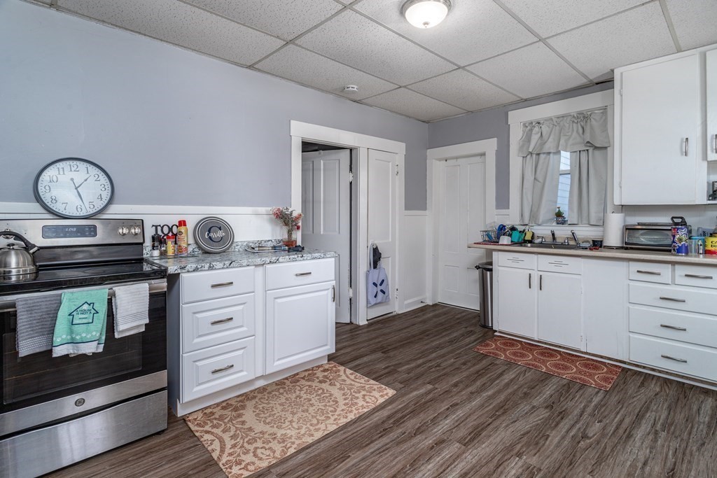 101-105 Baker Street Gardner, MA 01440 - Photo 27 of 37 a kitchen with a stove cabinets and wooden floor