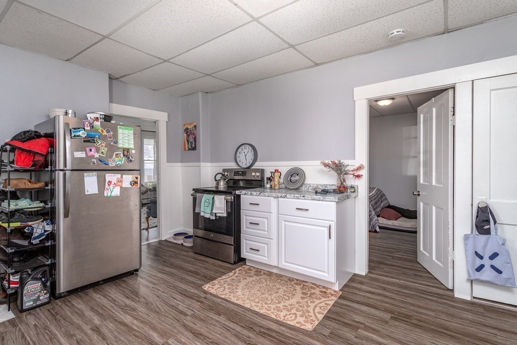 101-105 Baker Street Gardner, MA 01440 - Photo 28 of 37 a kitchen with granite countertop a refrigerator stove and wooden floor