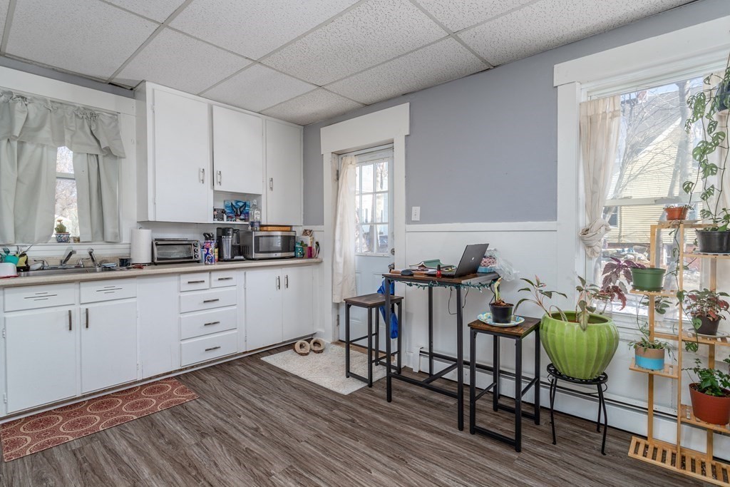 101-105 Baker Street Gardner, MA 01440 - Photo 31 of 37 a kitchen with a dining table chairs and cabinets