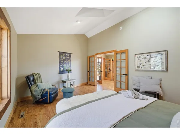 a bedroom with a bed and wooden floor