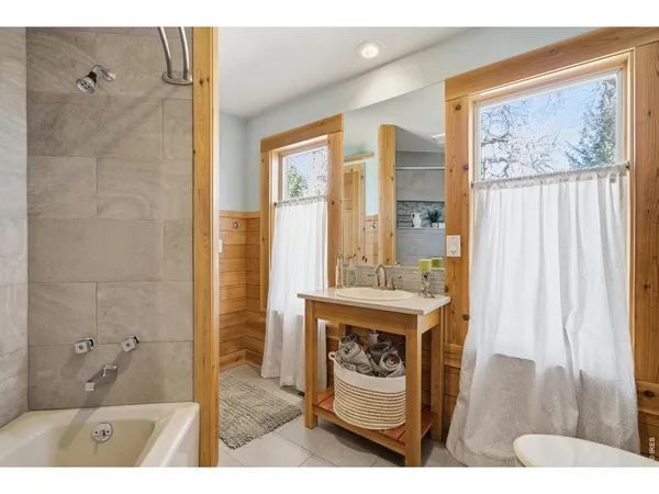 a bathroom with a wooden floor and a shower