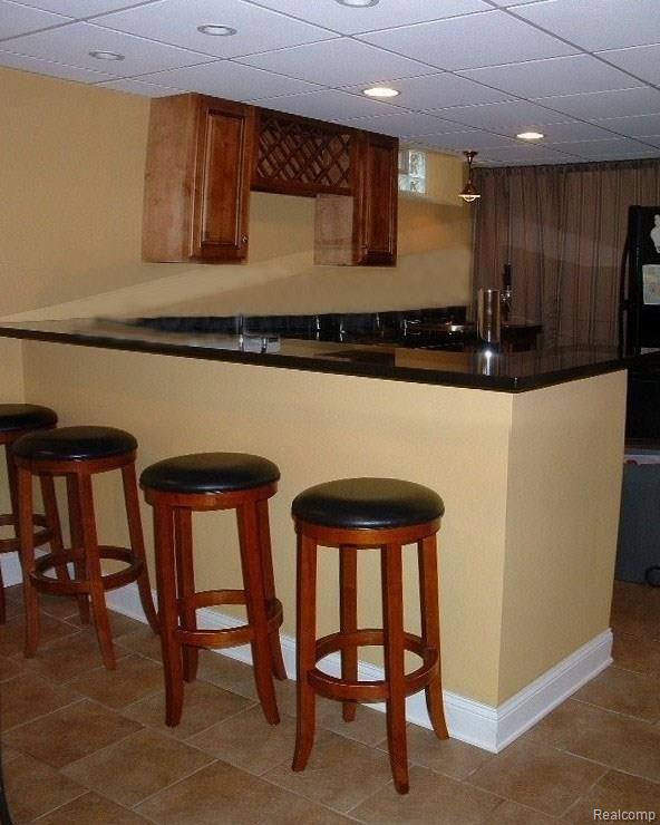 2478 Pembroke Road Birmingham, MI 48009 - Photo 33 of 38 Fantastic finished lower level's granite wet bar with kegger fridge, neutral ceramic tile & paint, recessed lights, adjoins a full granite kitchen including all appliances, gathering room/game room, full bath, & storage room/workshop