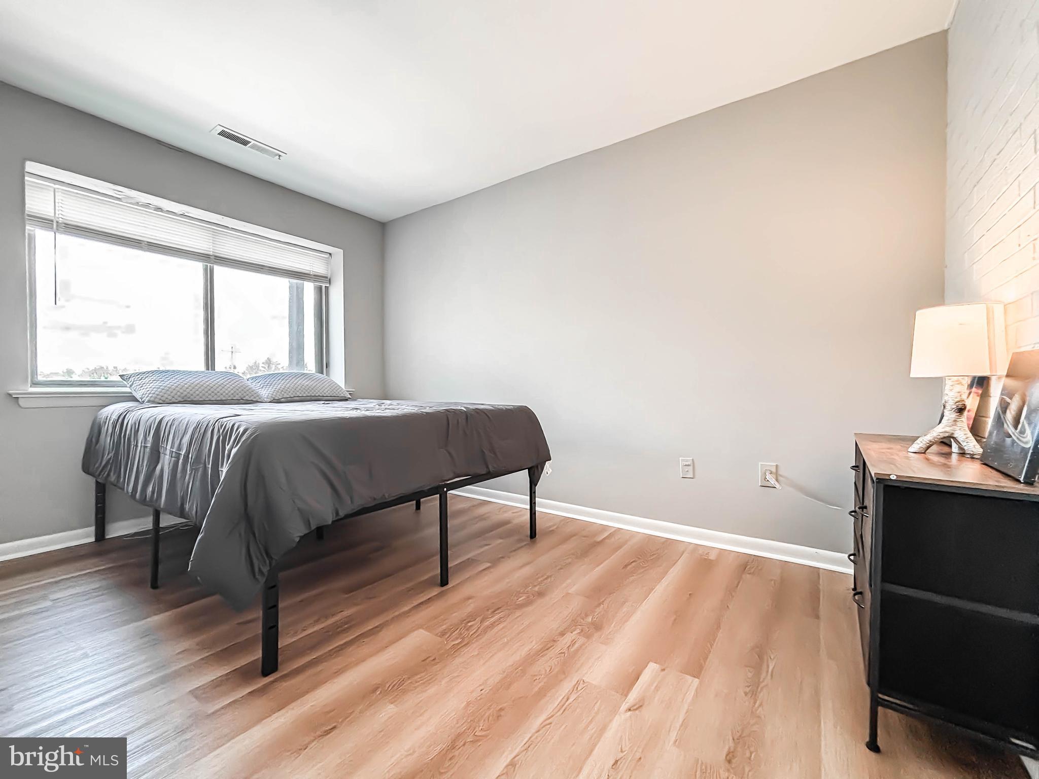 130 Slade Avenue, Unit 414 Baltimore, MD 21208 - Photo 25 of 48 a bedroom with a bed and a lamp