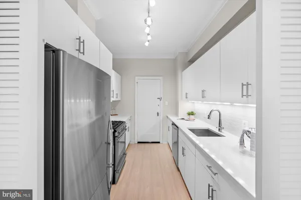 a kitchen with a sink a refrigerator and cabinets
