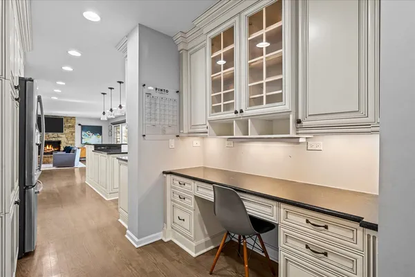 a kitchen with a refrigerator and white cabinets