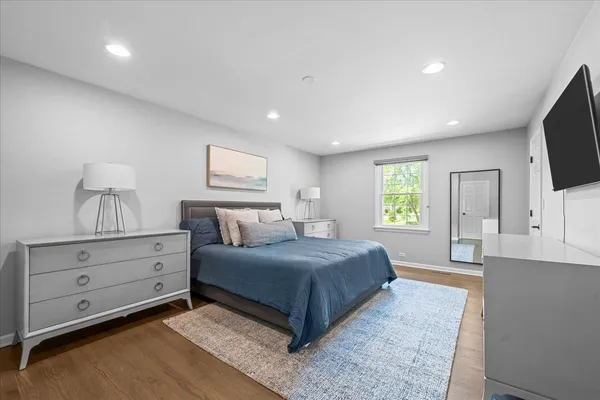 a spacious bedroom with a large bed and a flat screen tv