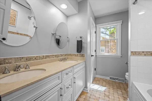 a spacious bathroom with a double vanity sink and a mirror