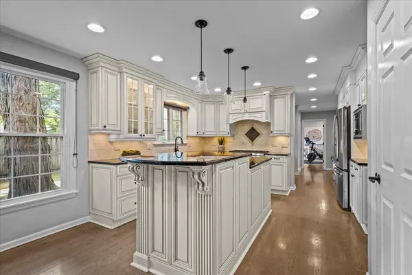 a kitchen with counter top space a sink stainless steel appliances and windows