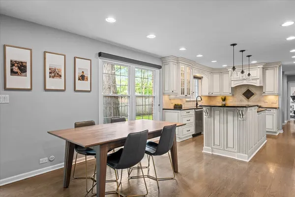 a kitchen with a table chairs microwave and cabinets