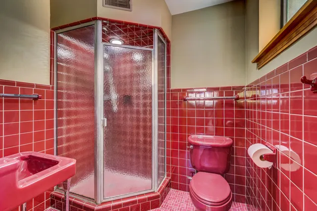 a bathroom with a toilet and a shower