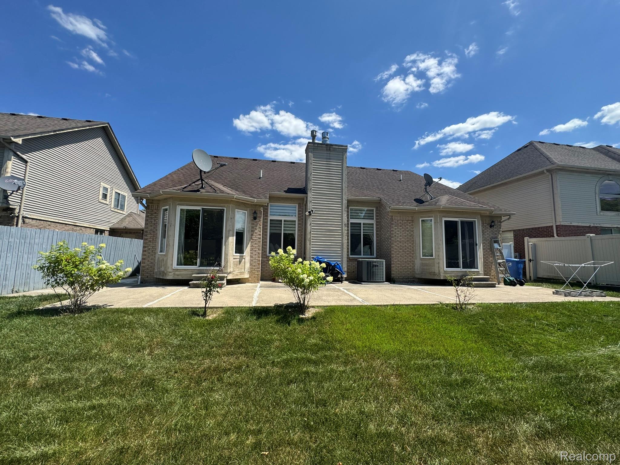 324 Cherry Lane Inkster, MI 48141 - Photo 4 of 28 Expansive rear patio featuring multiple access points, concrete paving, and surrounding green space