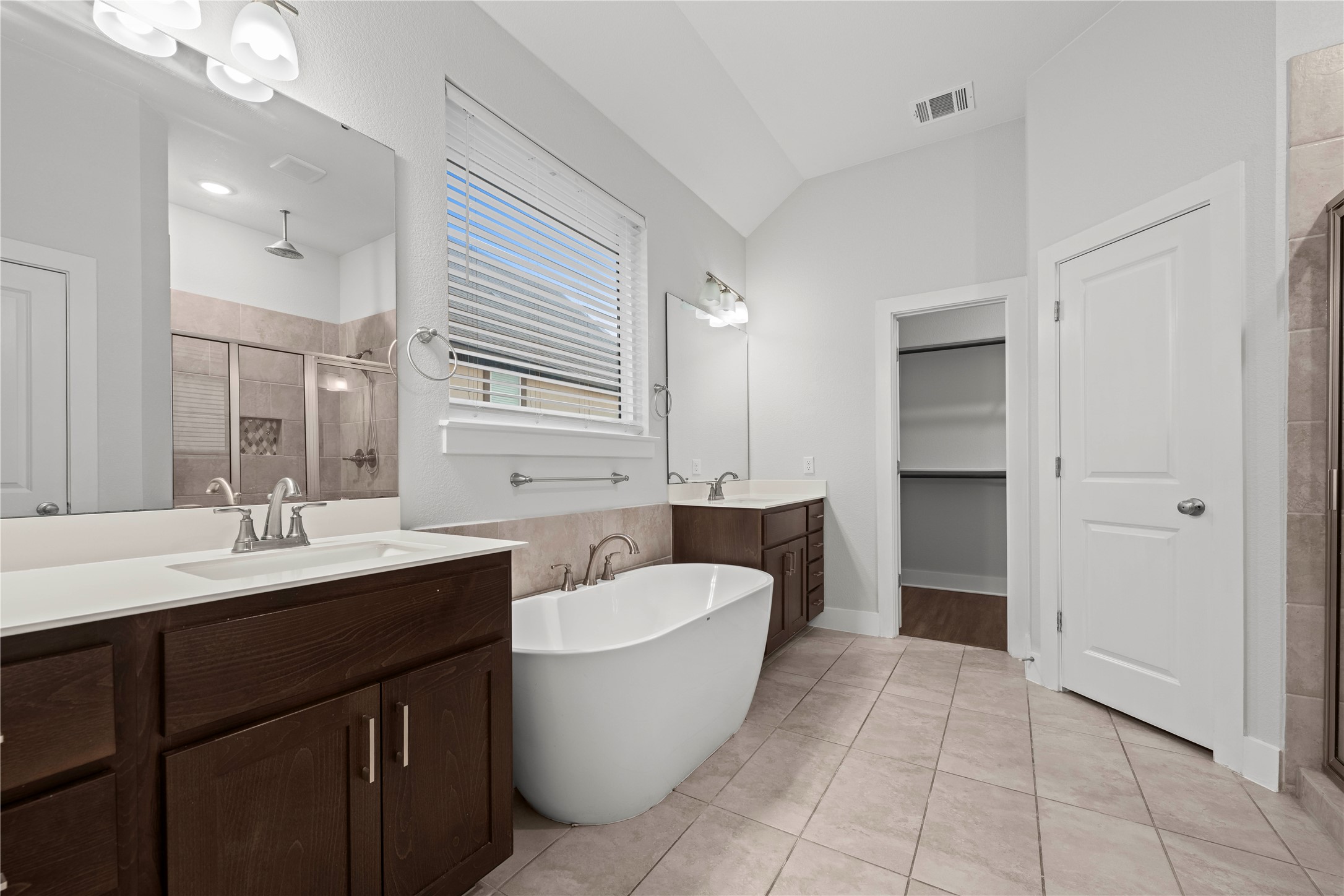 60 Rancho Trail Georgetown, TX 78628 - Photo 16 of 36 Tile flooring and vaulted ceilings frame this bathroom complete with a freestanding soaking tub.