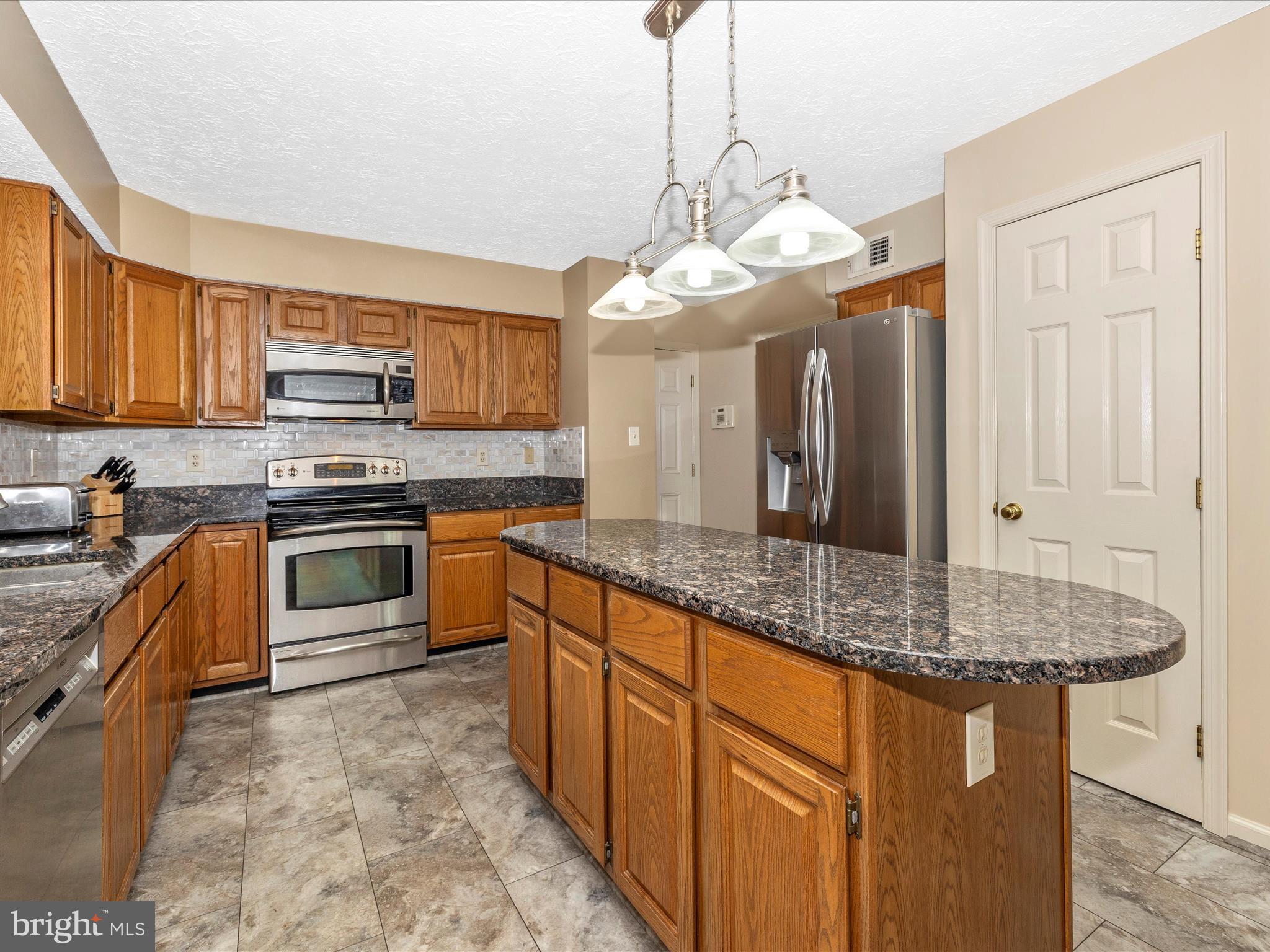 10 Knoll Side Lane Middletown, MD 21769 - Photo 15 of 84 a kitchen with stainless steel appliances granite countertop a stove sink and cabinets