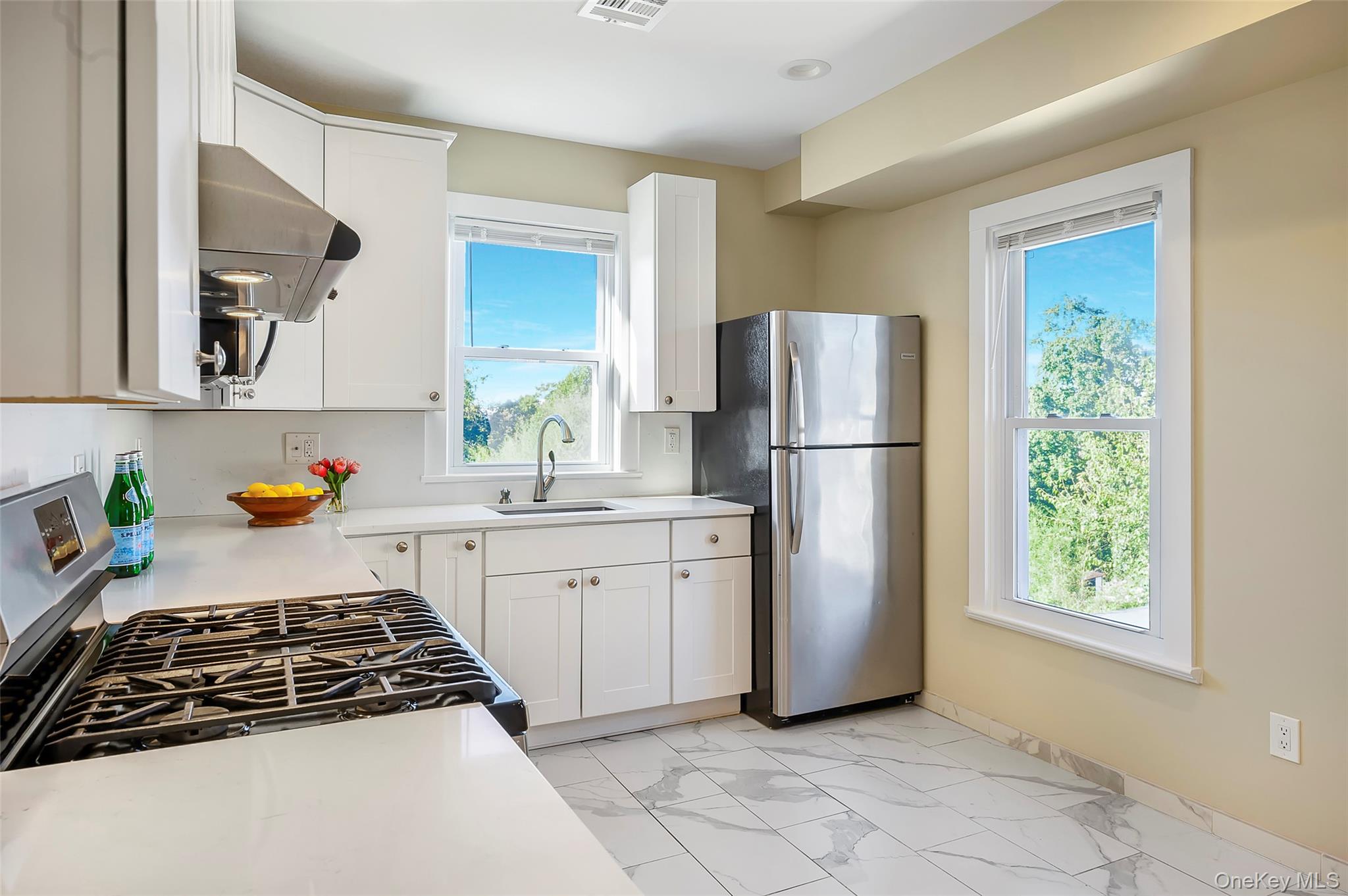 9 Todd Place, Unit 2ND FL RIGHT SIDE Ossining, NY 10562 - Photo 11 of 20 Kitchen with appliances with stainless steel finishes, light marble finish flooring, ventilation hood, and white cabinets