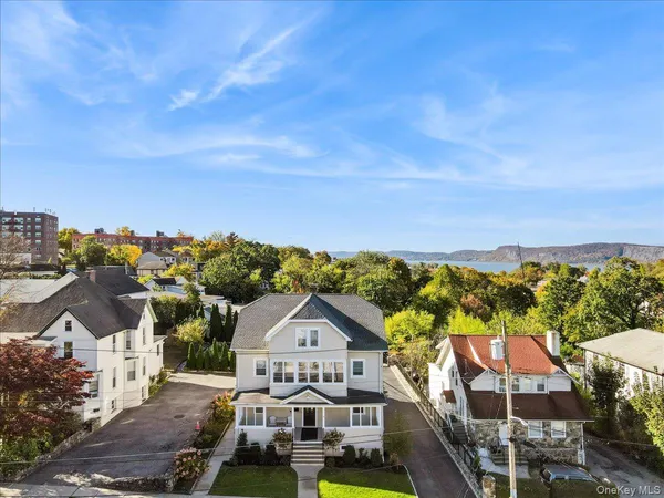 a view of a white house with large windows and a small yard