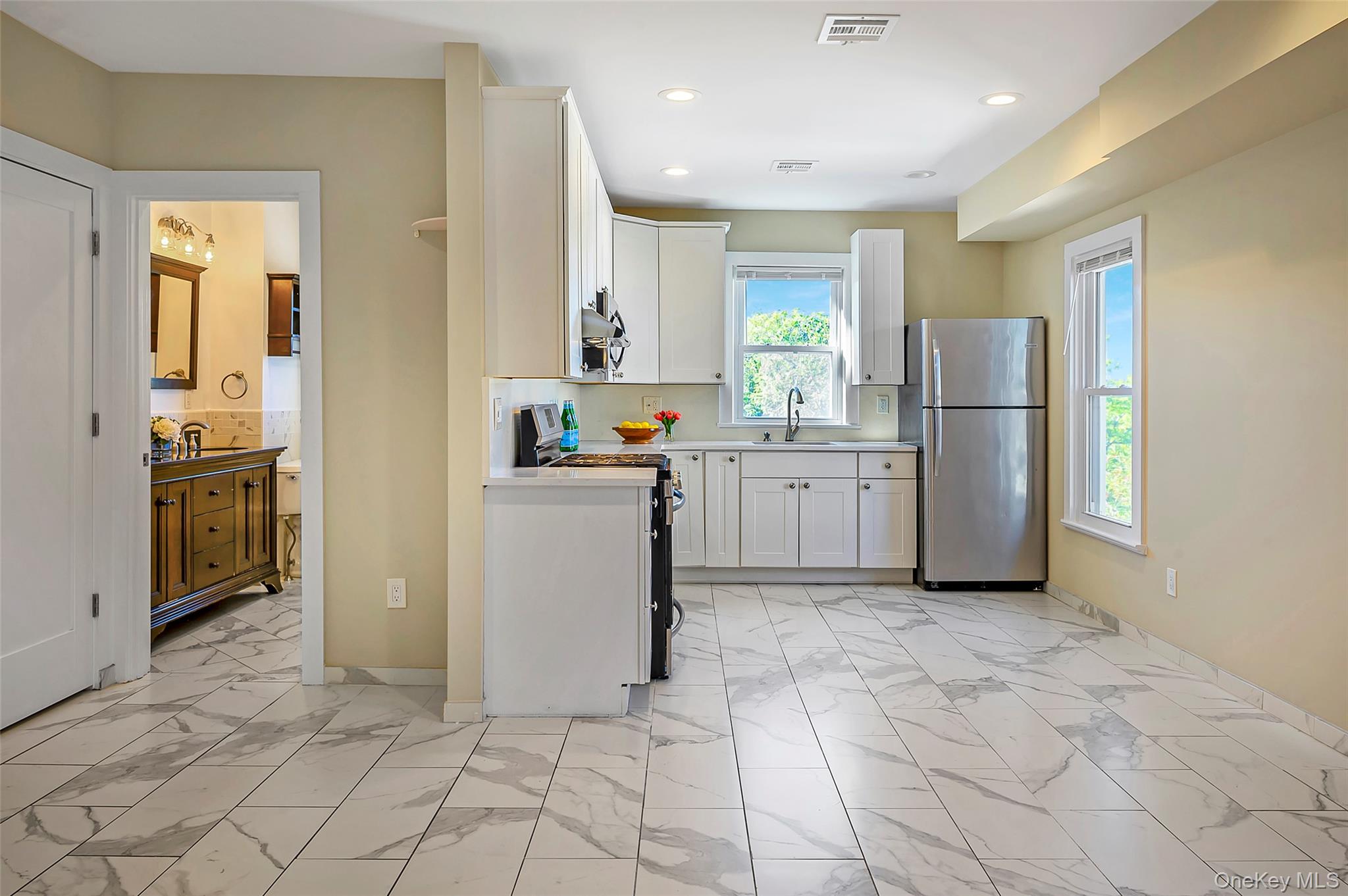 9 Todd Place, Unit 2ND FL RIGHT SIDE Ossining, NY 10562 - Photo 10 of 20 Kitchen with stainless steel appliances, light marble finish flooring, white cabinetry, light countertops, and recessed lighting