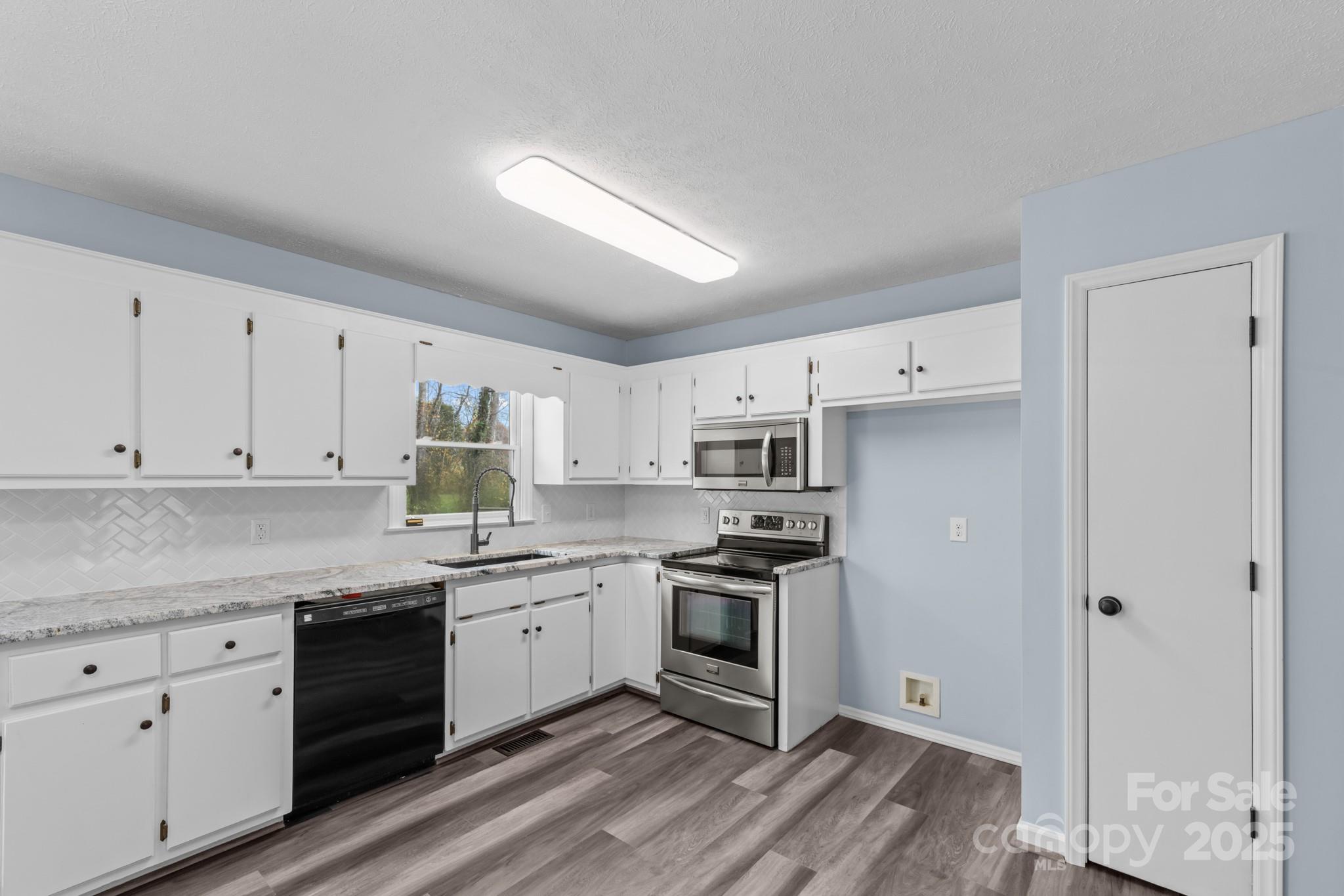 2830 Ellerwood Road Hudson, NC 28638 - Photo 30 of 46 a kitchen with stainless steel appliances granite countertop a stove a sink and white cabinets