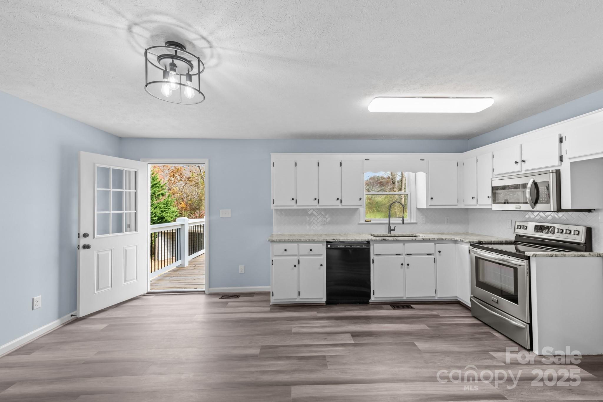 2830 Ellerwood Road Hudson, NC 28638 - Photo 31 of 46 a kitchen with stainless steel appliances granite countertop a stove sink and cabinets