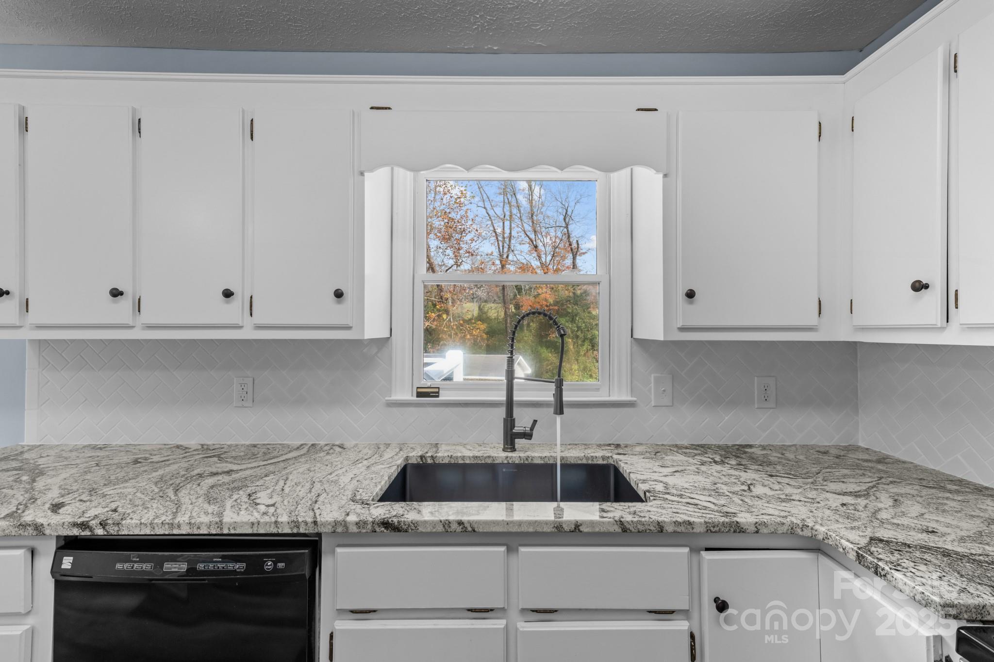 2830 Ellerwood Road Hudson, NC 28638 - Photo 32 of 46 a kitchen with granite countertop white cabinets and a stove
