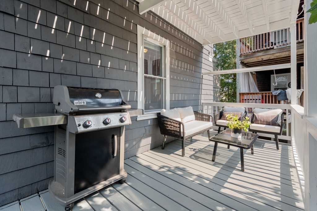 103 Dix Street, Unit 2 Boston, MA 02122 - Photo 16 of 23 a patio with couches a fire pit and wooden floor