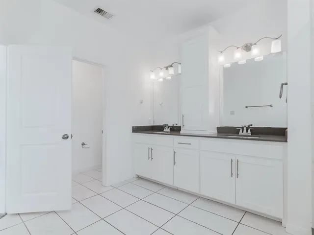 a bathroom with a double vanity sink and a mirror