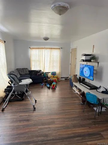 a living room with furniture hard wood floor and a window