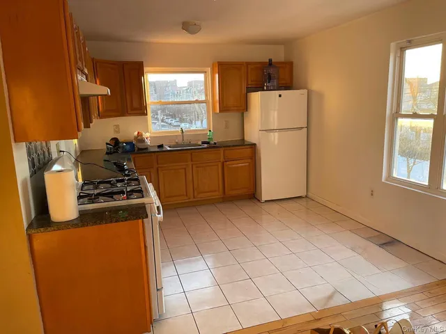 a kitchen with a refrigerator sink stove and cabinets