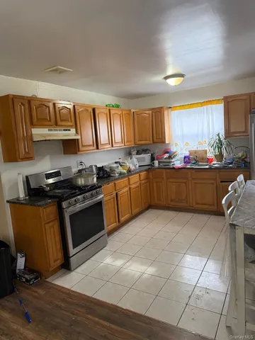 a kitchen with stainless steel appliances granite countertop a stove a sink and a refrigerator