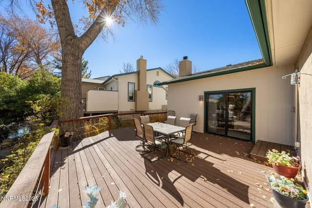 a roof deck with table and chairs and potted plants