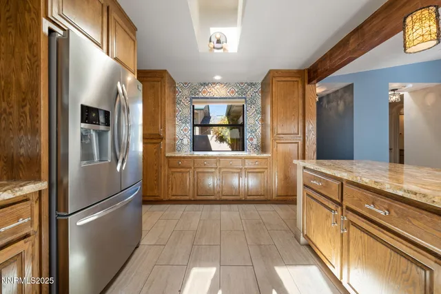 a kitchen with granite countertop a refrigerator and a sink