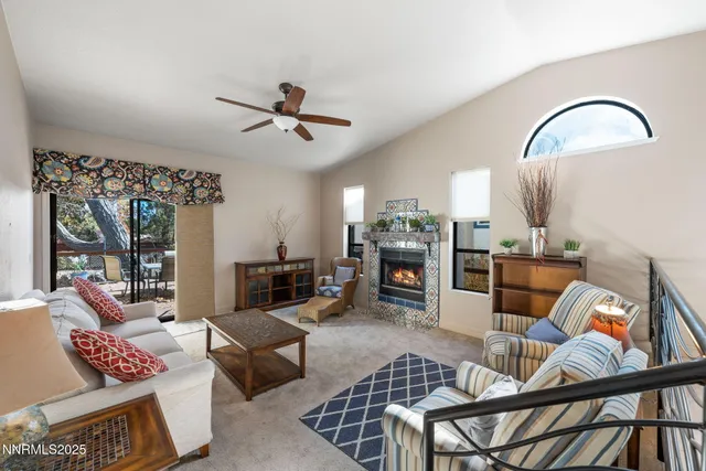 a living room with furniture a flat screen tv and a floor to ceiling window
