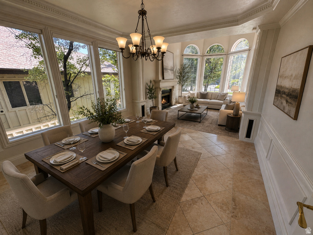 11902 Autumn Ridge Drive East Sandy, UT 84092 - Photo 13 of 20 Open-concept dining and living area featuring large bay windows, a built-in fireplace with a stone surround, and elegant crown molding AI-staged or enhanced
