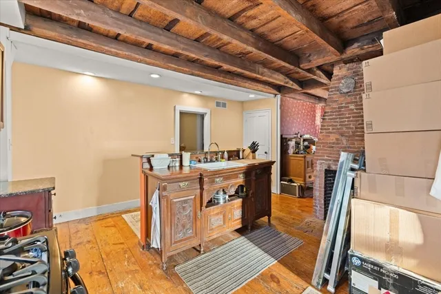 a room with stainless steel appliances kitchen island granite countertop a sink and wooden cabinets