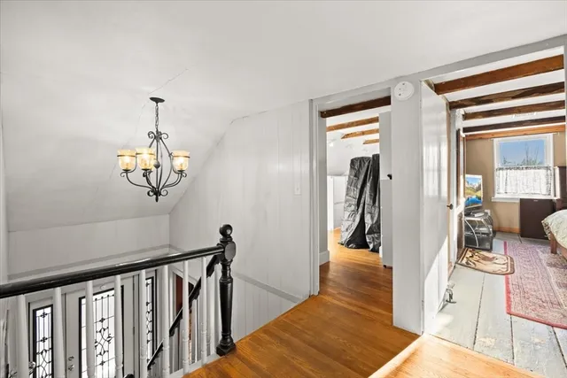 a view of a hallway with furniture and a chandelier