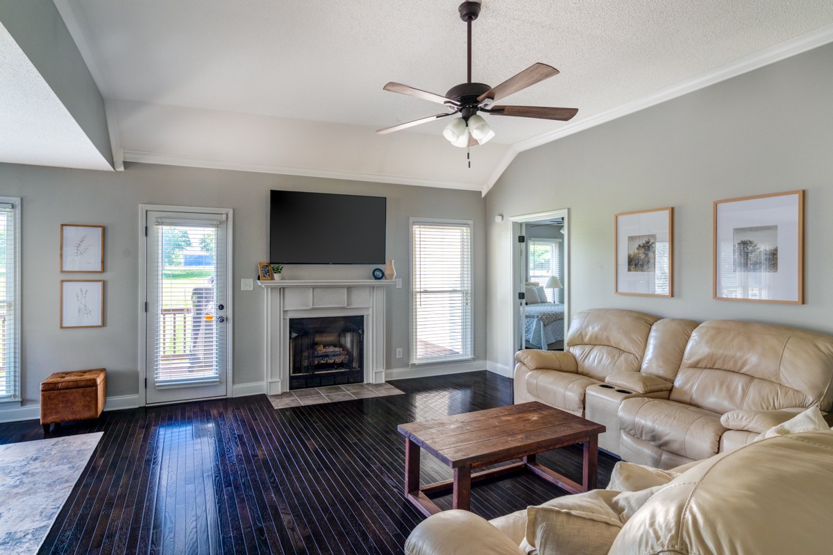 883 South Ridge Trail Clarksville, TN 37043 - Photo 7 of 42 Relax in this living room with a gas fireplace, elevated ceilings, a fantastic view of the stunning lawn, and more of those stunning hardwoods